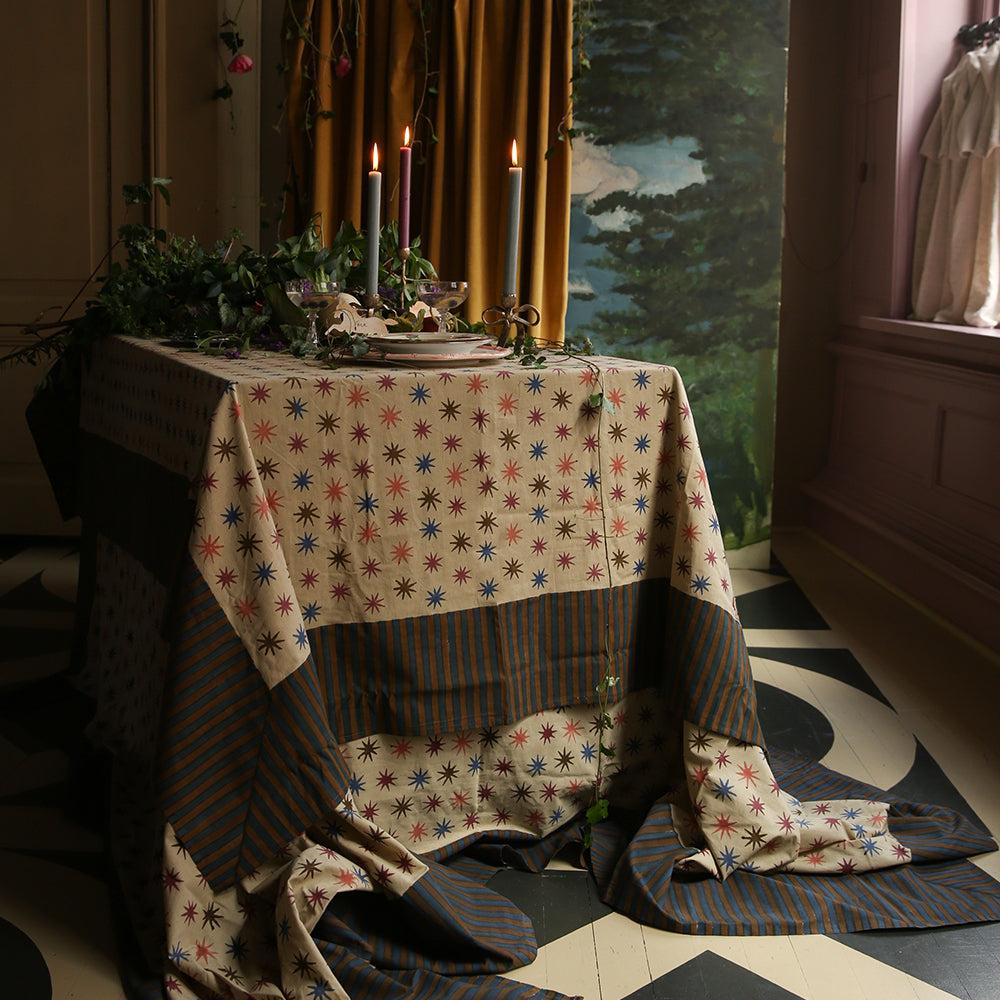 Familiediner in kerstsfeer met het Noa Sterren Tafelkleed als blikvanger, perfect voor feestelijke bijeenkomsten en lange tafels.