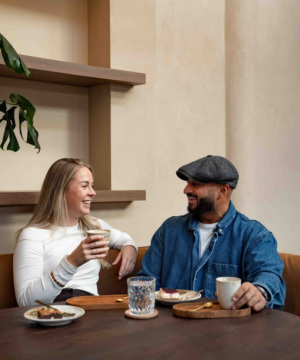 Nikki en Stephan, de oprichters van DIYOURTABLE, genieten samen van een gezellig koffiemoment aan een sfeervol gedekte tafel – het hart achter hun missie om mensen te verbinden aan tafel.