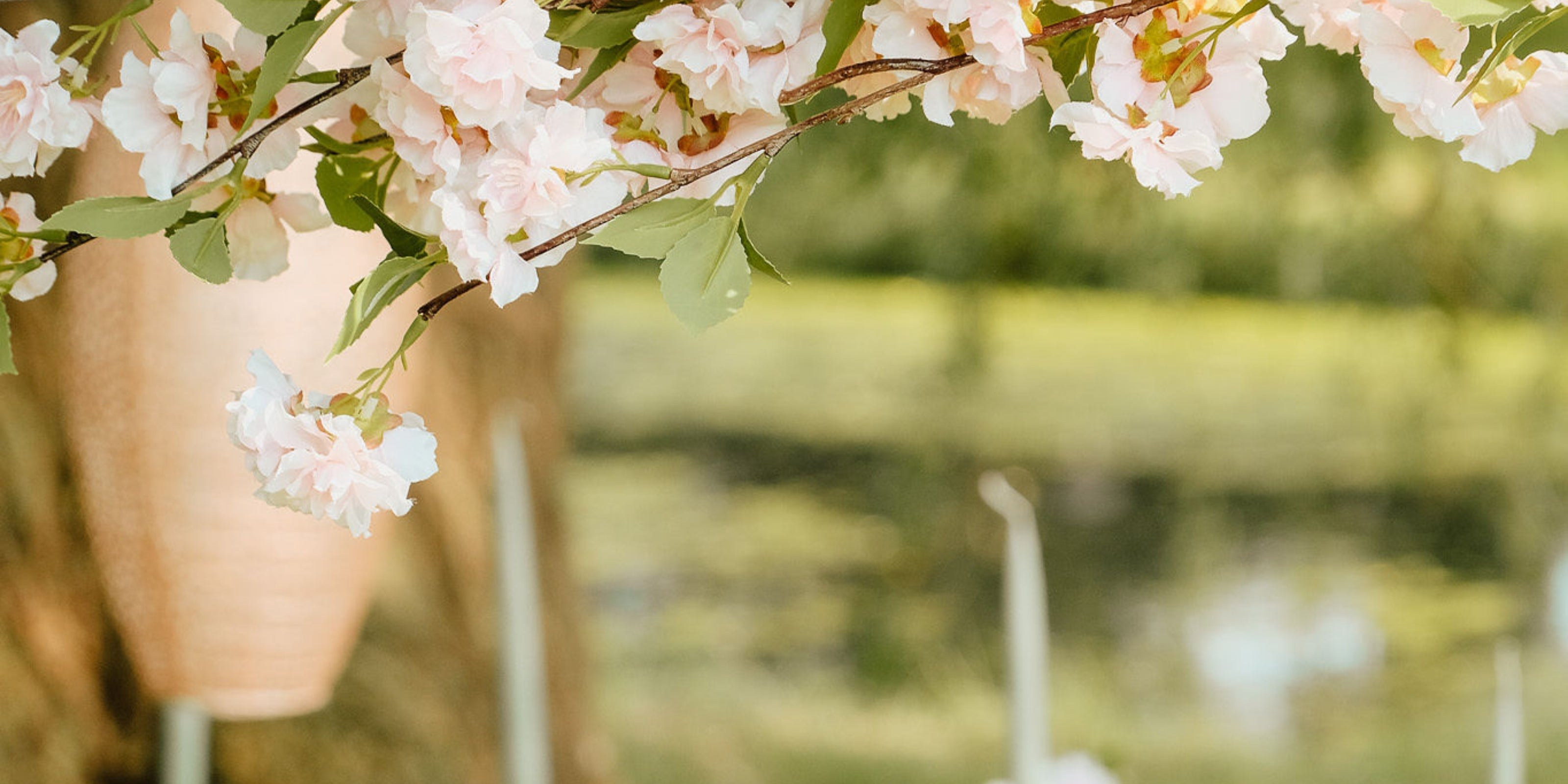 Flatlay van een betoverende Japanse tafelsetting met roze sakura, bamboe details en een zachtroze Aziatische solar lampion, stralend in een warme en serene sfeer.