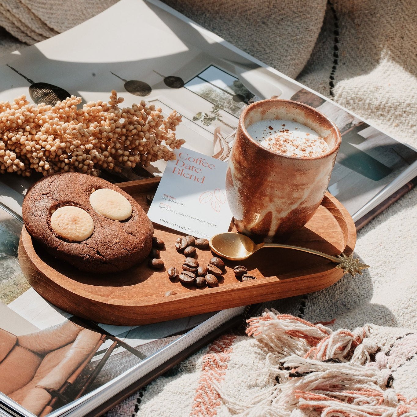 Warme koffie ervaring met Coffee Date Blend, chocoladekoekje en ambachtelijke cappuccino op een houten dienblad, omringd door cozy decoratie, perfect voor ontspannen momenten.